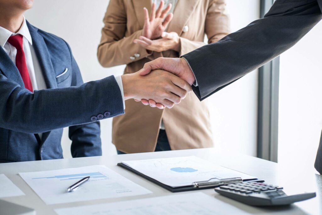 AI for Credit Unions: Unlocking Member Loyalty Through Personalization 4 Business professionals sealing a credit union partnership with a handshake after discussing AI-driven member engagement strategies