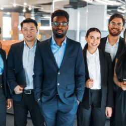 Diverse marketing team standing confidently in a modern office — experts in digital strategies for credit unions.