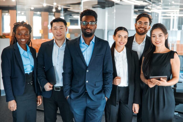 Diverse marketing team standing confidently in a modern office — experts in digital strategies for credit unions.