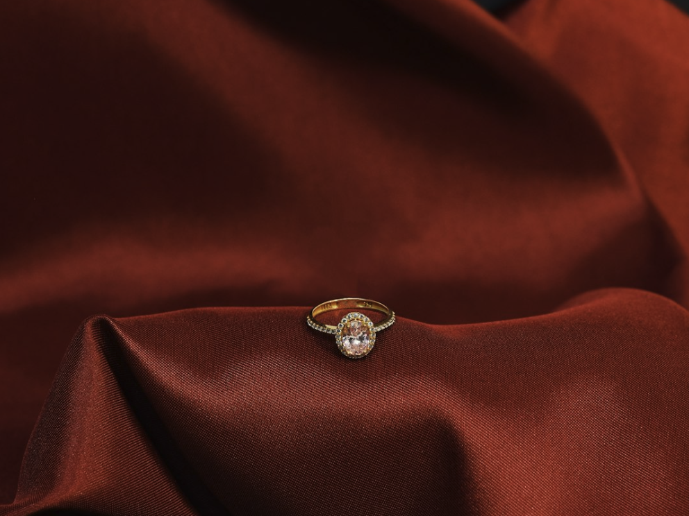 Diamong ring placed on a vevelt red background. House with distinct archtiecture with blue sky as background. Full-service marketing agencies